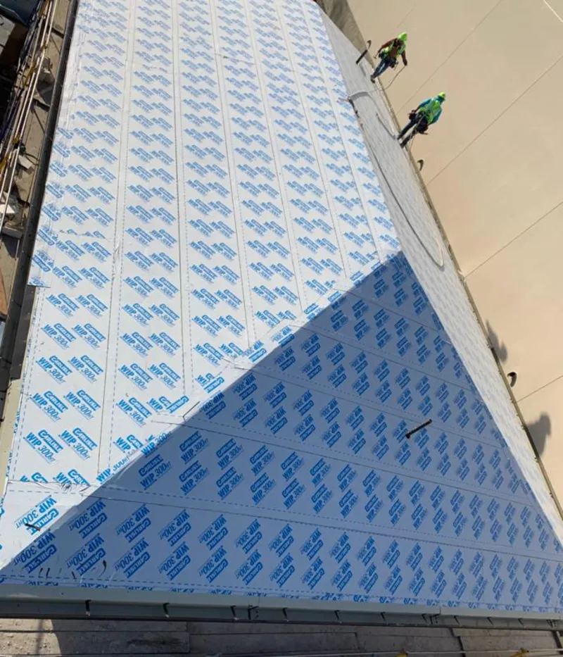 Professional roofers installing underlayment on a metal roof in Bee Ridge